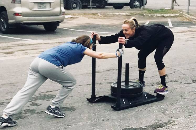 Mother pushing sled at Maximstrong gym